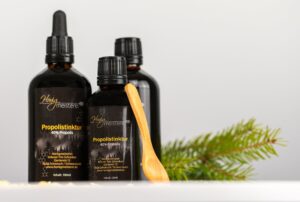 Propolis-Tinktur 40 % der Honigmeisterei in mehreren Flaschen mit Holzlöffel und Tannenzweig